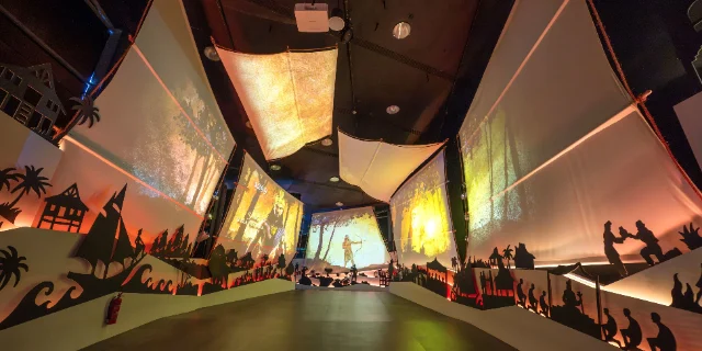 A gallery at Singapore Discovery Centre with lit fabric sails and silhouette scenes along the walls